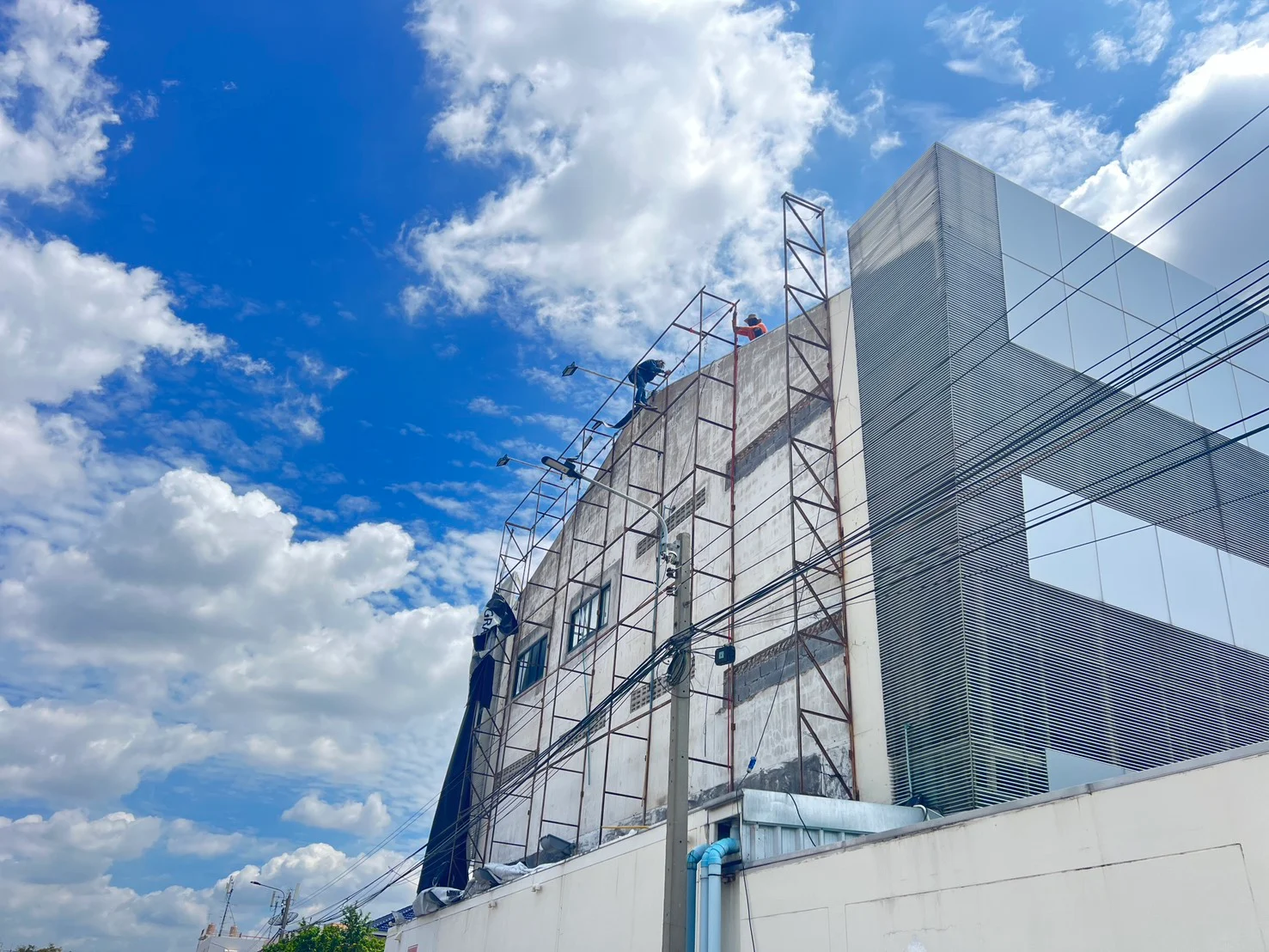 ภาพหน้างานจริง การรื้อถอนโครงเหล็ก Truss ป้ายโฆษณาบนผนังอาคารพาณิชย์